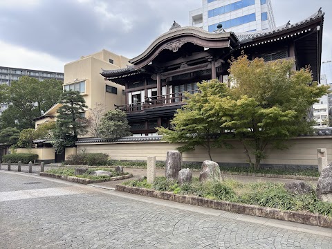 Tochoji Temple's main hall, its gracefully curved karahafu gable facing the street, with a rock garden in front. Tochoji was